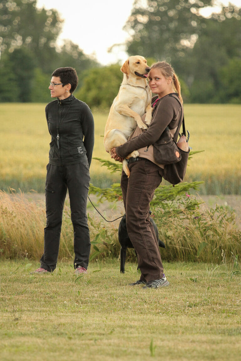 A girl holding a Labrador in her arms