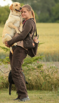 A girl holding a Labrador in her arms